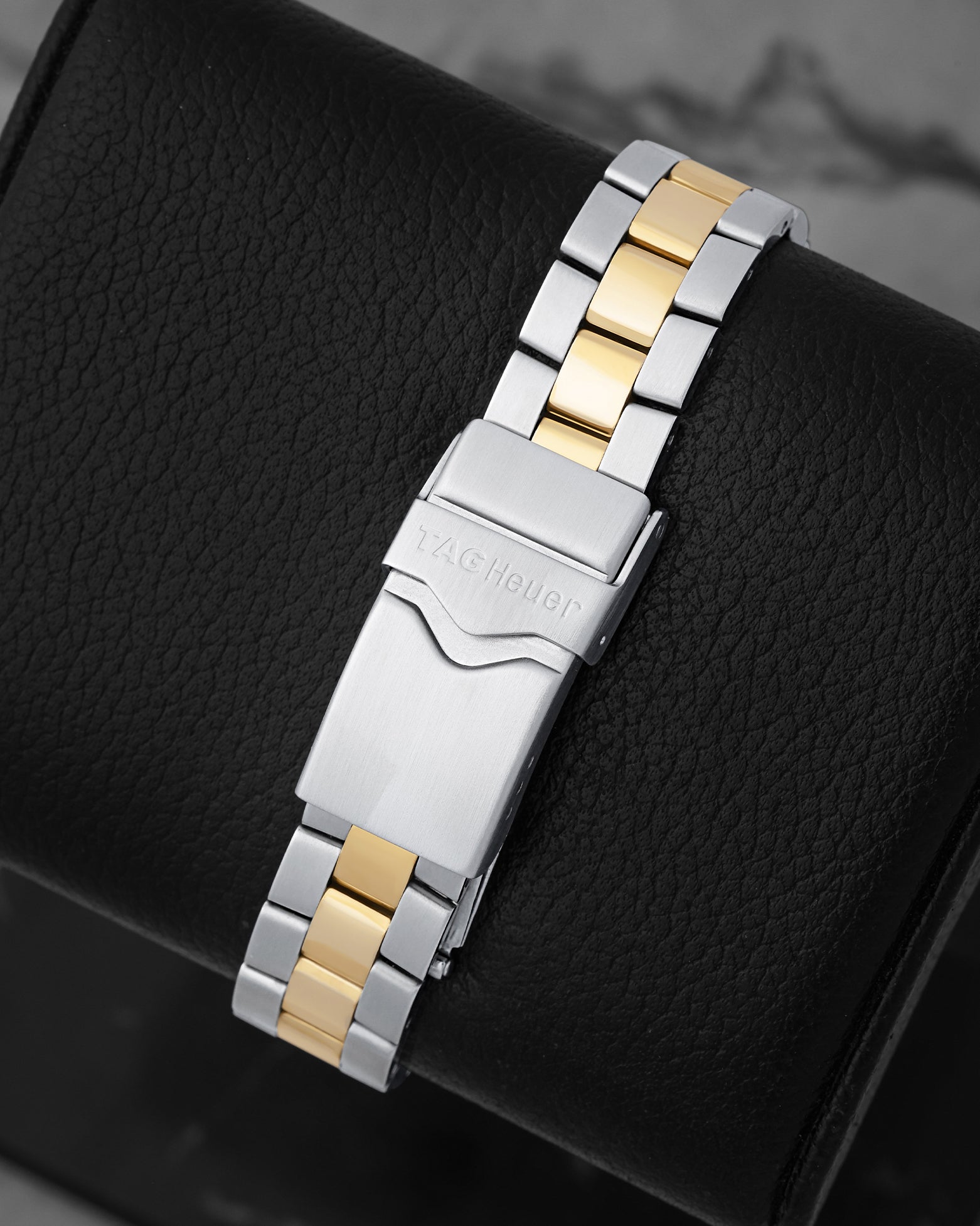 Rear view of the two-tone steel and yellow gold-plated link bracelet showing the folding deployment clasp with safety lever stamped with the TAG Heuer shield logo