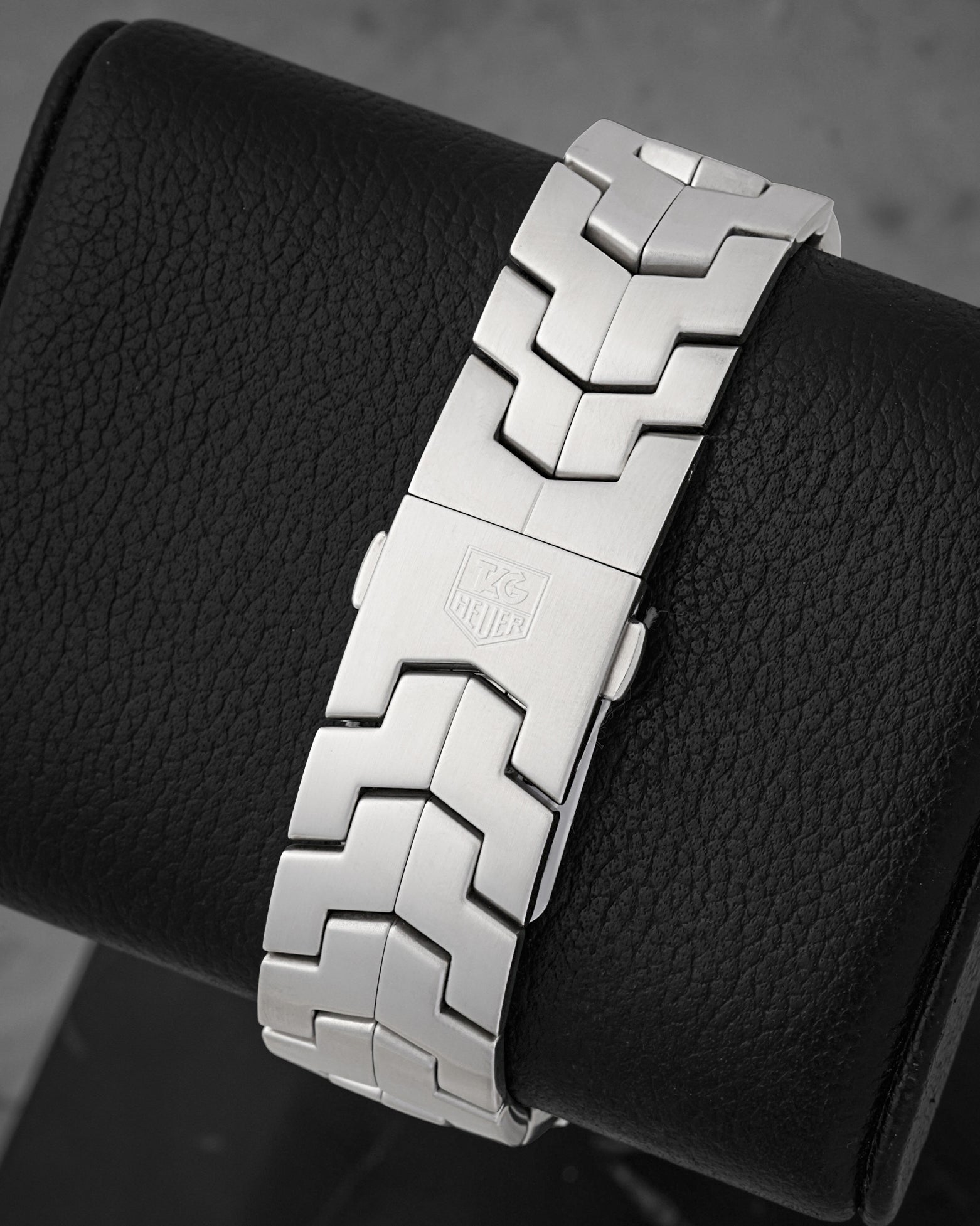 Rear view of the iconic satin-finished interlocking S-shape metal link bracelet focusing on the flush and secure low-profile folding safety clasp stamped with the Heuer shield