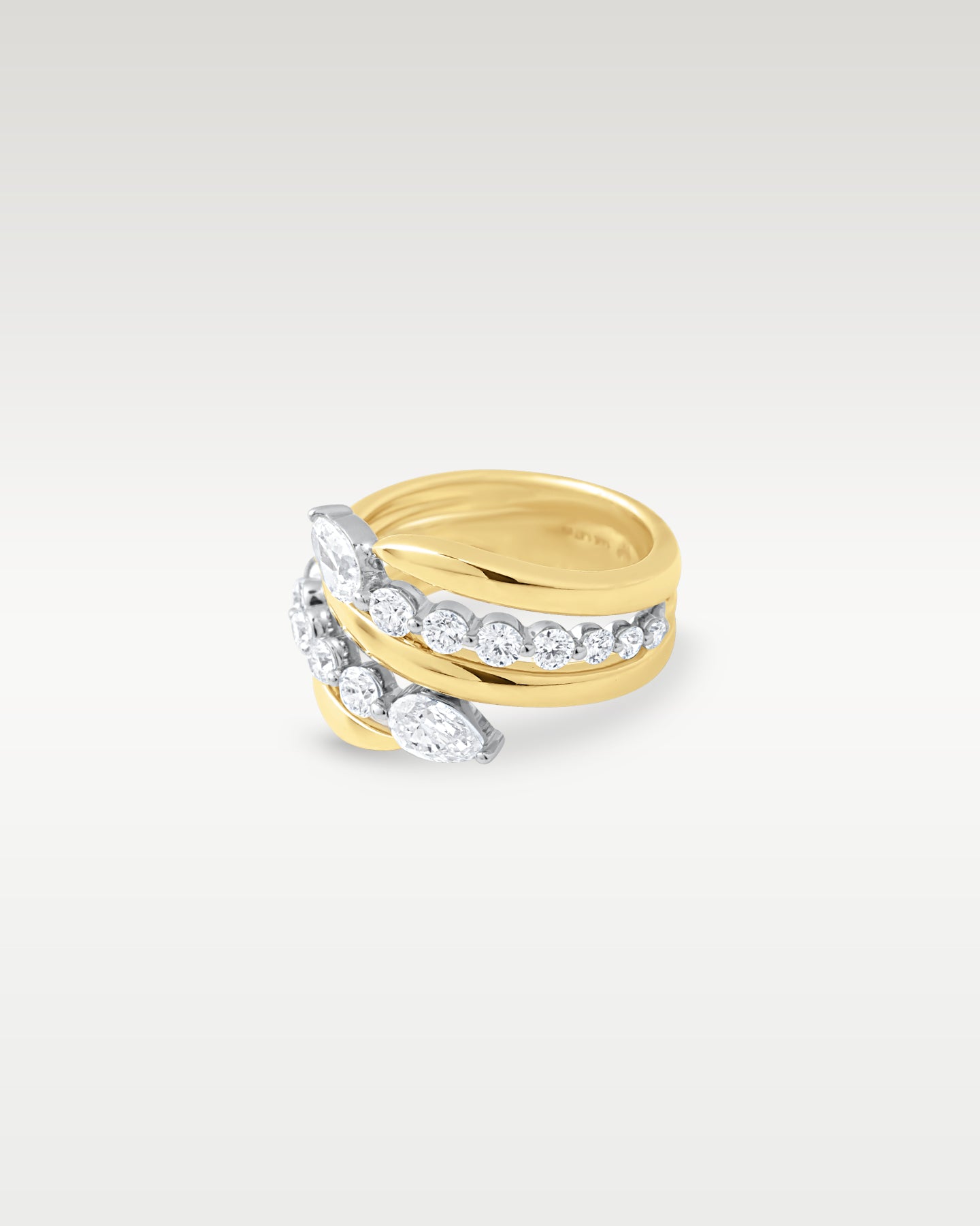 angled view showing the bypass wrap design and multi-band yellow gold layout set with diamonds