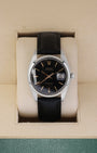 Vintage 1987 Rolex Oysterdate Precision 6694 with a black gilt dial and black leather strap resting inside a Rolex box
