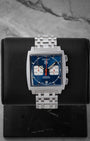 Pre owned 2005 TAG Heuer Monaco Automatic Chronograph CW2113.BA0780 with blue dial, square case, and stainless steel bracelet at Noahs Fine Watches and Jewelry in Dallas TX