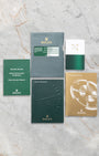 The official Rolex international guarantee card, user manual booklets, and factory papers laid out on a gray marble surface