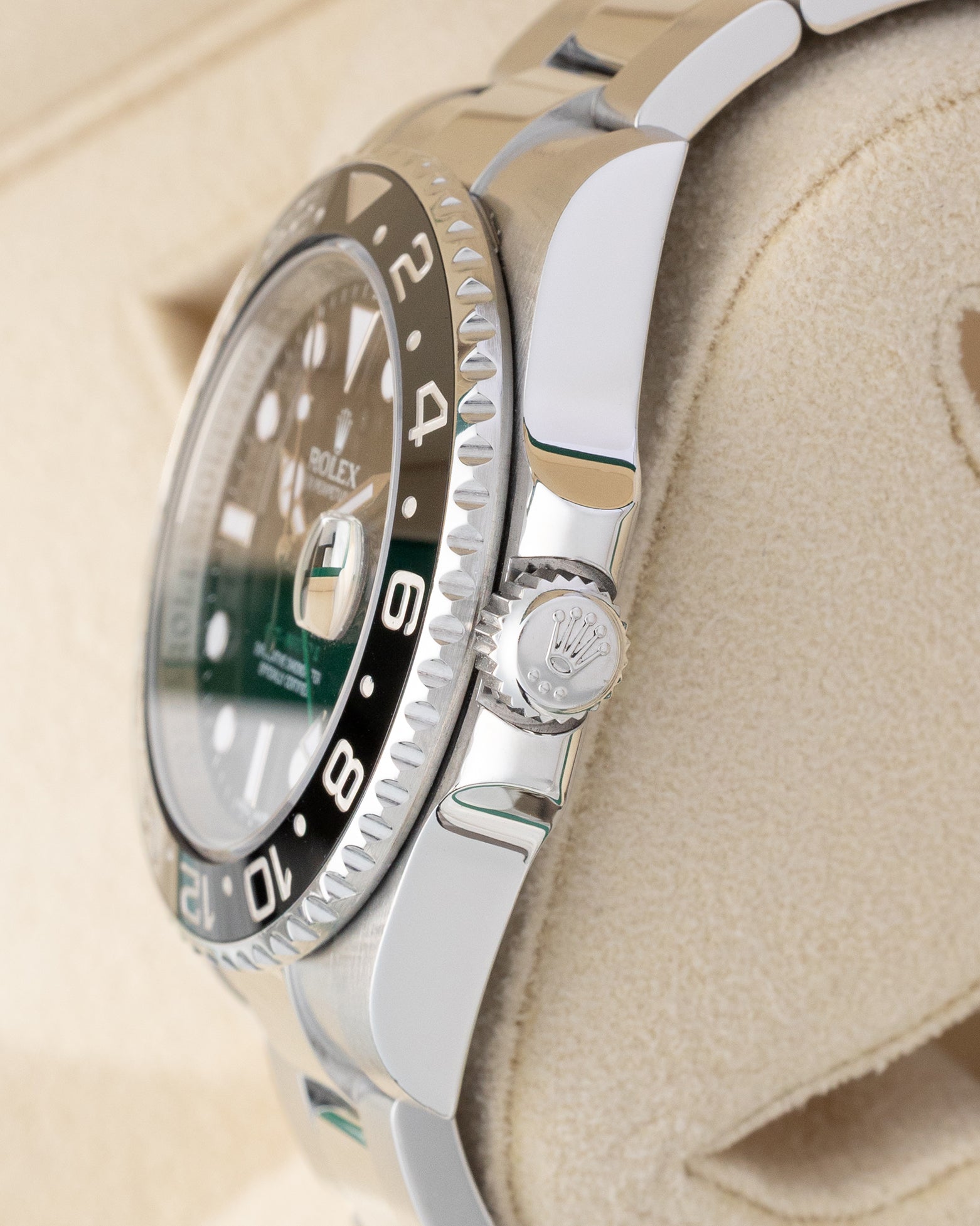 Side profile detail showing the 40mm stainless steel case, crown guards, and signed Triplock winding crown on a Rolex GMT-Master II 116710LN