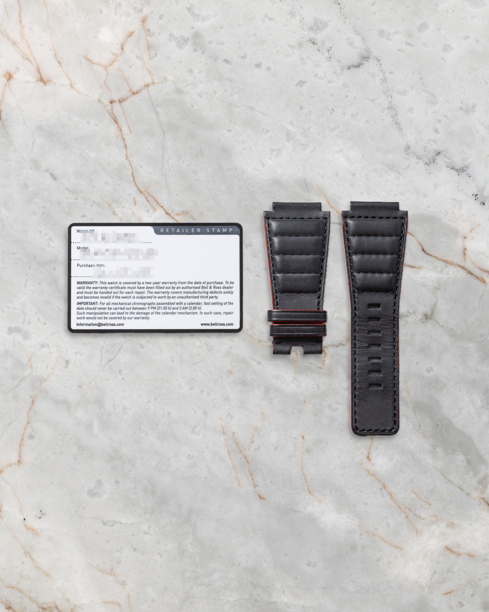 Official Bell and Ross international guarantee warranty card resting beside an unmounted replacement black leather racing strap