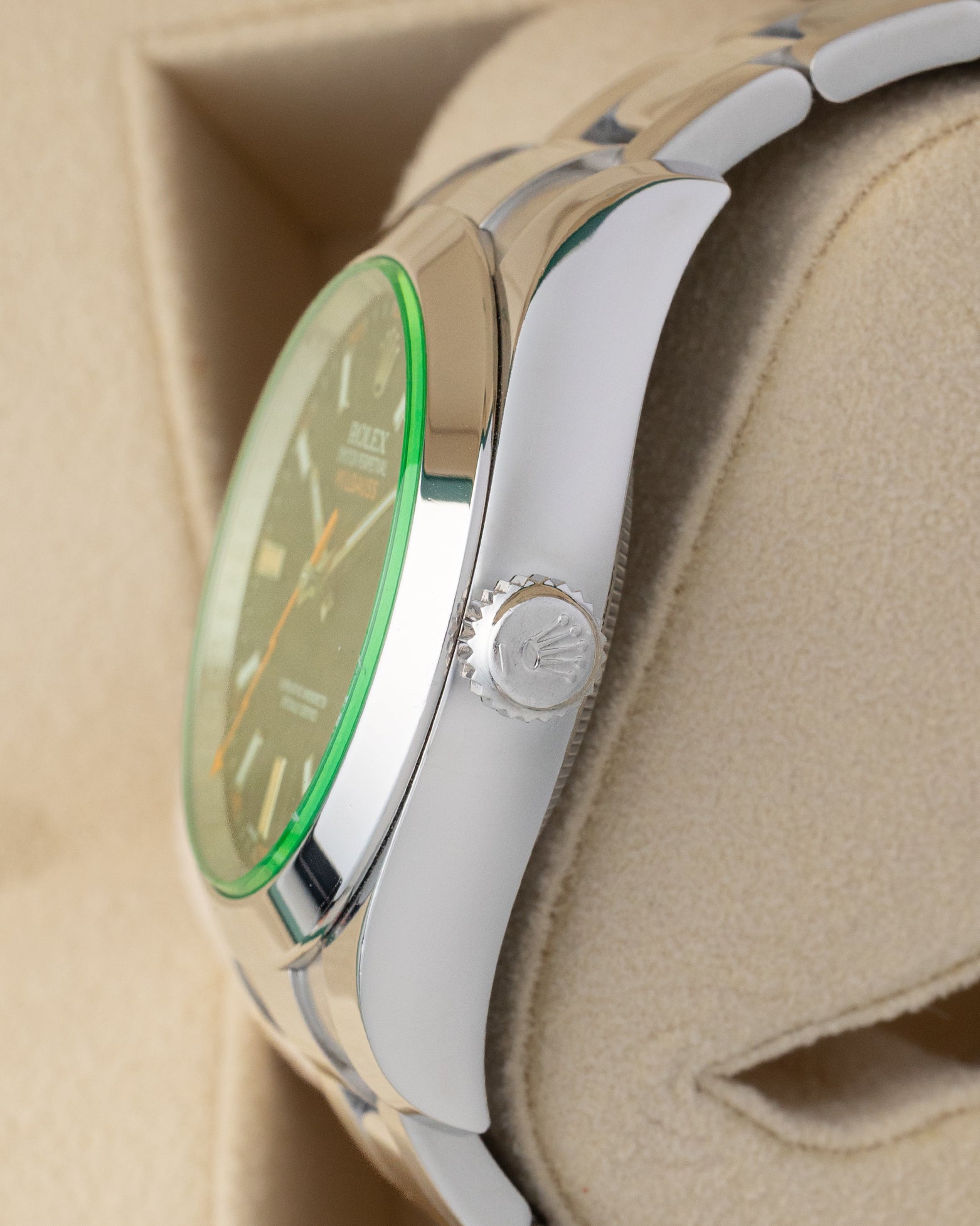 Side profile detail showing the 40mm stainless steel antimagnetic case, signed Twinlock winding crown, and green sapphire edge on a Rolex Milgauss 116400GV