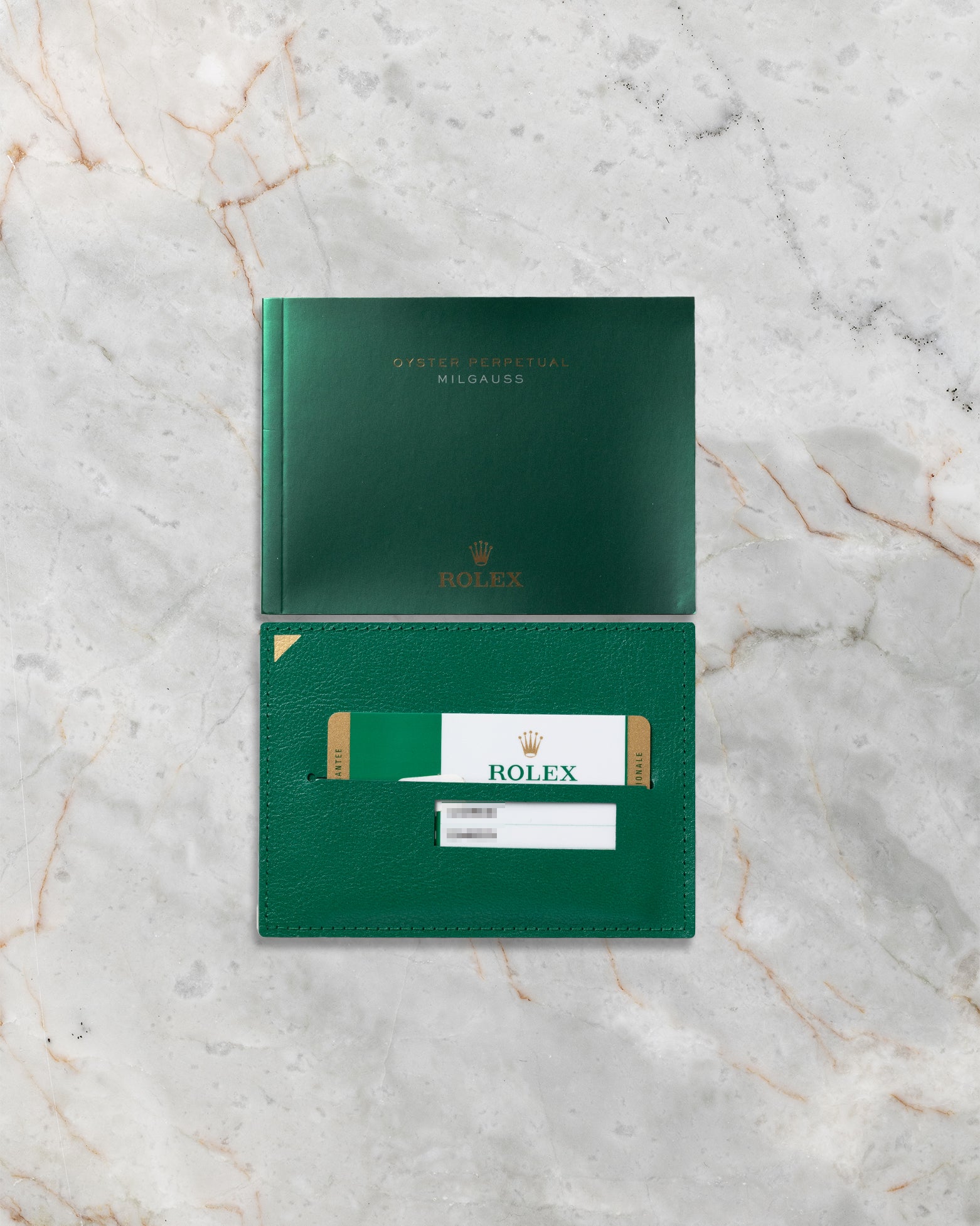 Official Rolex international guarantee card, green leather holder, and Milgauss user manual for reference 116400GV