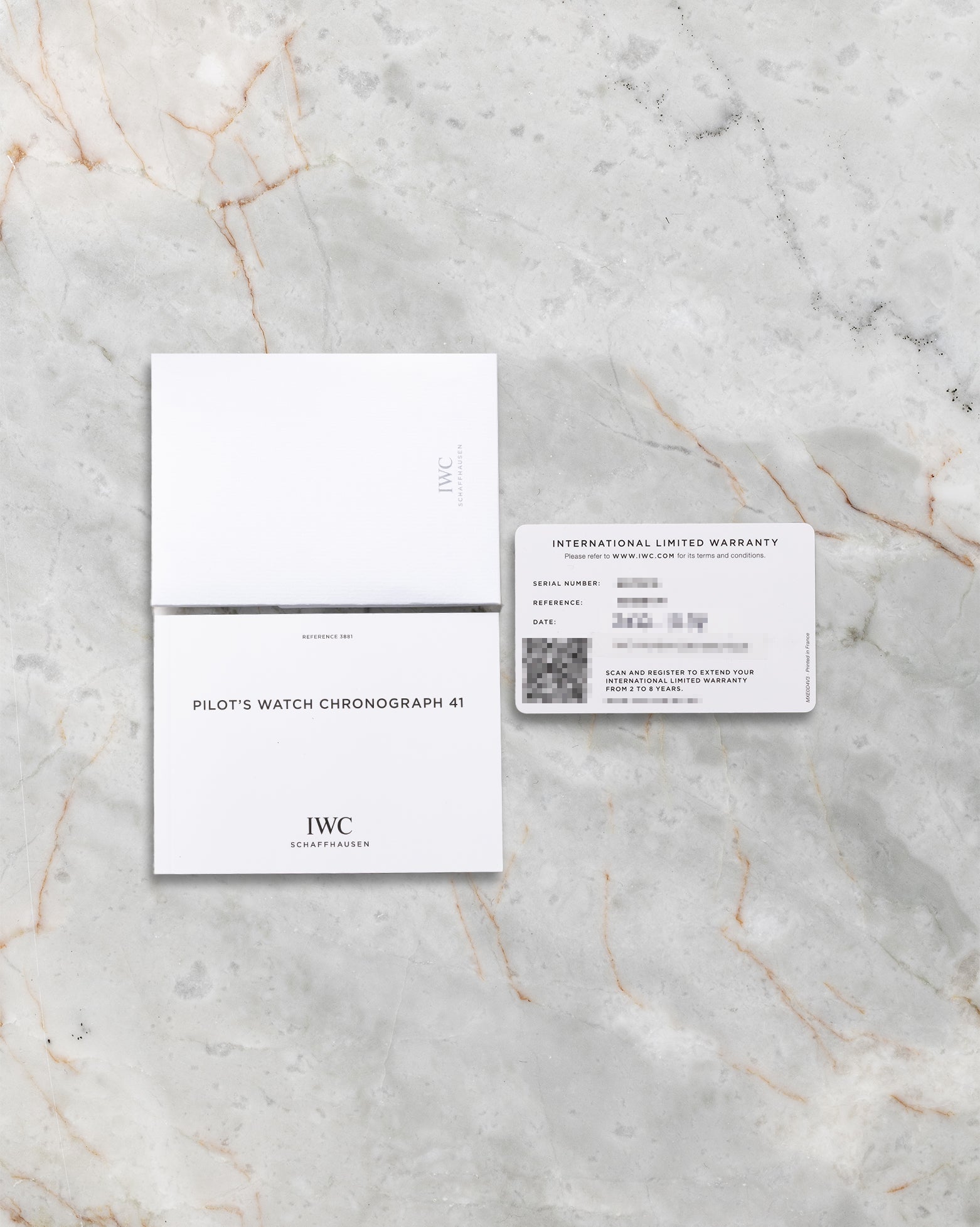 The official printed IWC international warranty card dated 2022, shown alongside the user manuals and registration documents at Noahs Fine Watches and Jewelry Dallas
