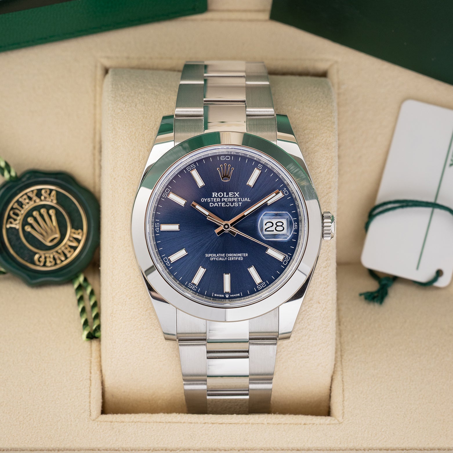 front portrait of a 2024 Rolex Datejust 41 126300 watch with a blue sunray dial and Oyster bracelet resting inside its luxury green presentation box