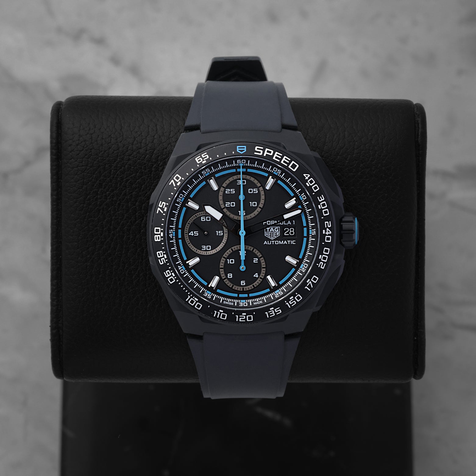 2025 TAG Heuer Formula 1 Automatic Chronograph CBZ2084.FT8097 with a black dial and blue racing accents on a black display stand