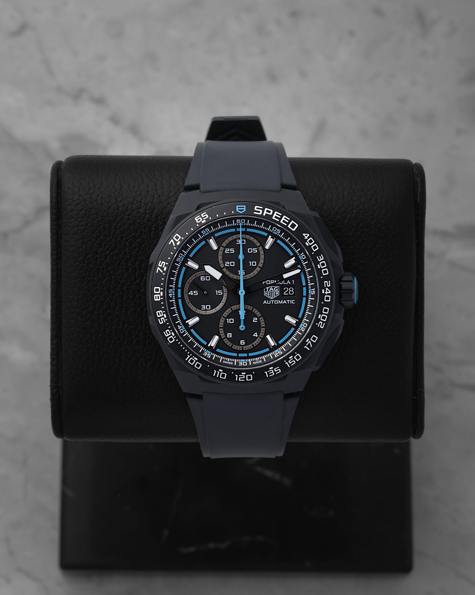 2025 TAG Heuer Formula 1 Automatic Chronograph CBZ2084.FT8097 with a black dial and blue racing accents on a black display stand