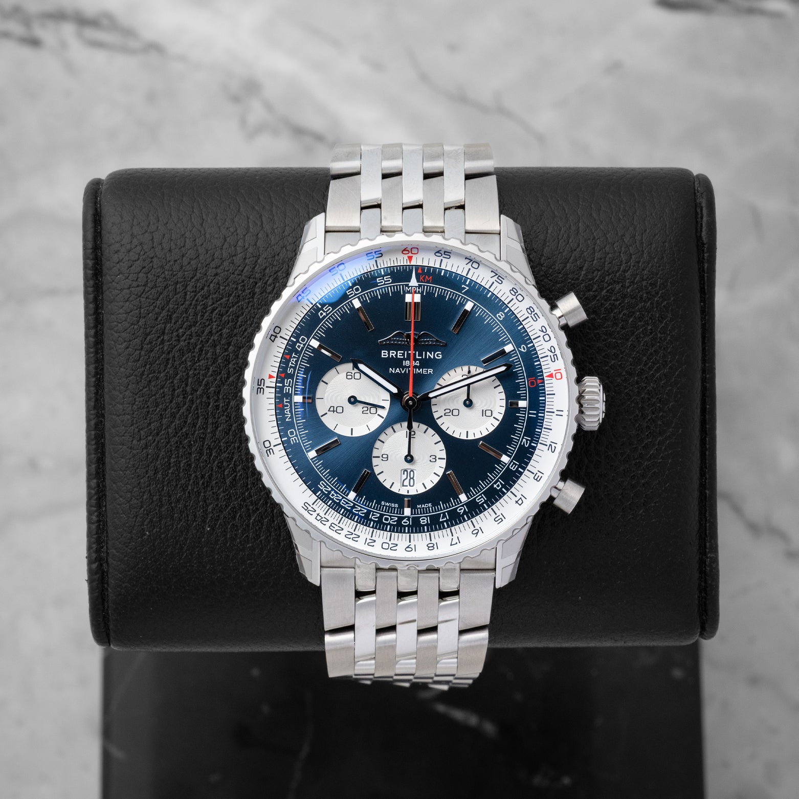 2026 Breitling Navitimer B01 Chronograph 46 AB0137 featuring a blue dial with white sub-dials on a black display stand