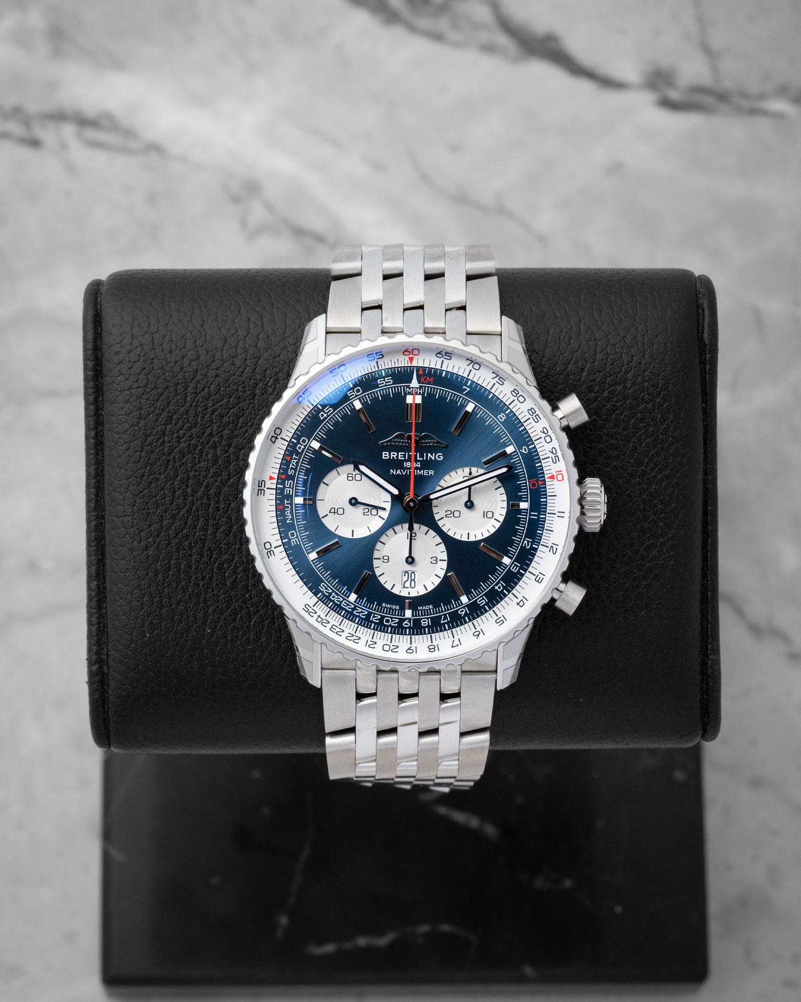 2026 Breitling Navitimer B01 Chronograph 46 AB0137 featuring a blue dial with white sub-dials on a black display stand