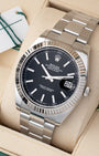 Angled view of Rolex Datejust 41 126334 featuring intense black stick dial, 18k white gold fluted bezel, and Oyster bracelet
