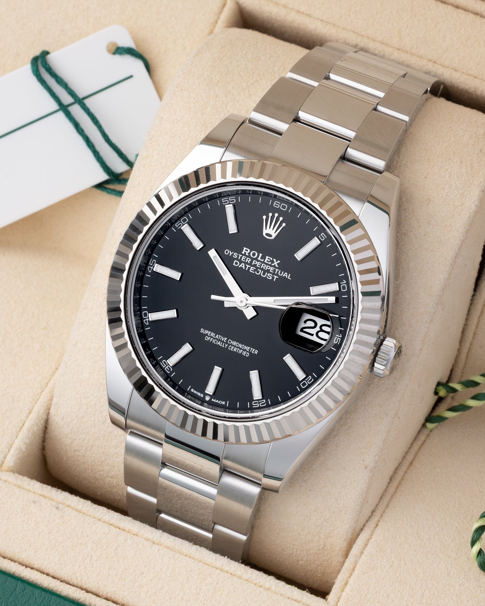 Angled view of Rolex Datejust 41 126334 featuring intense black stick dial, 18k white gold fluted bezel, and Oyster bracelet