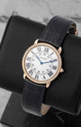Angled shot of a Cartier Ronde Louis dress watch showcasing the classic black Roman numerals and blue apple-shaped hands