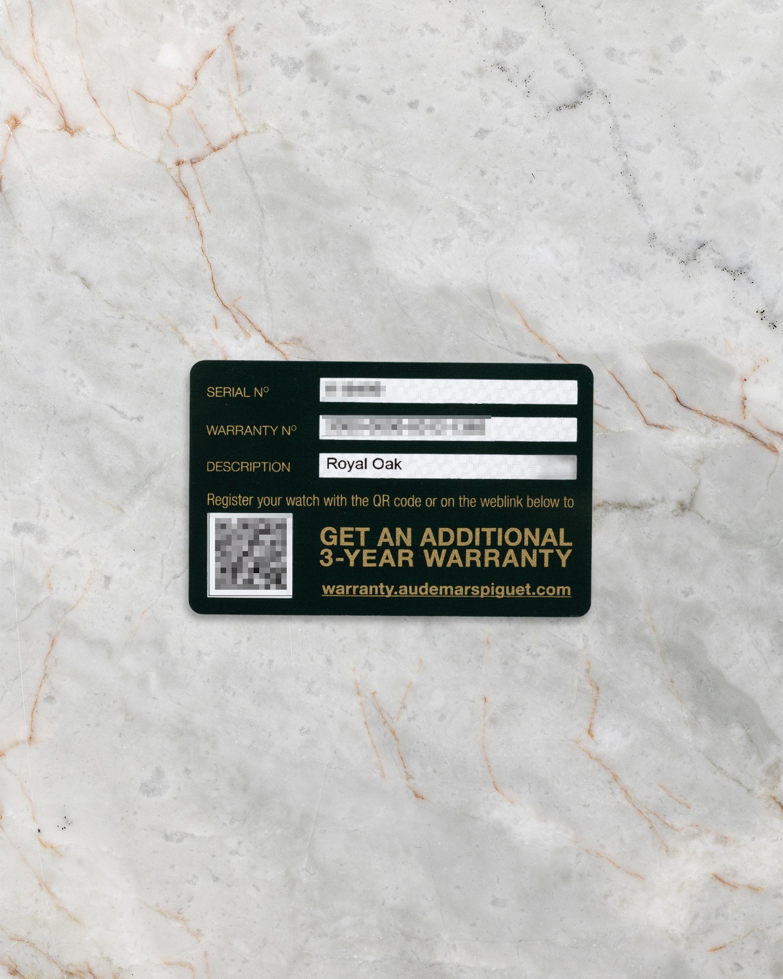 black and green Audemars Piguet international warranty activation card showing the registration barcode flat-laid on a gray marble surface
