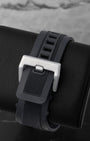 Rear view of the heavy-duty black synthetic rubber Bell and Ross strap secured with its wide satin-finished steel pin tang buckle clasp