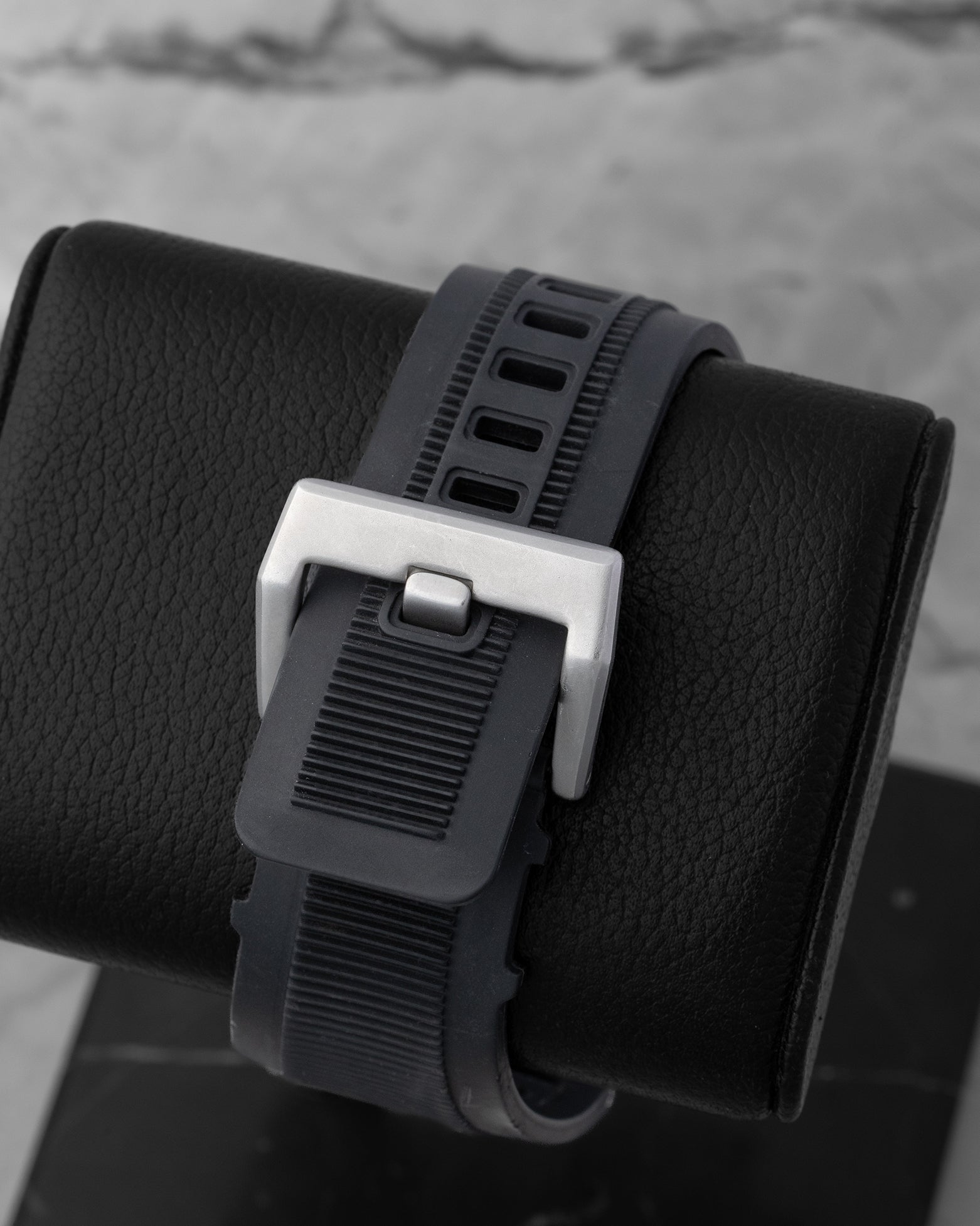 Rear view of the heavy-duty black synthetic rubber Bell and Ross strap secured with its wide satin-finished steel pin tang buckle clasp