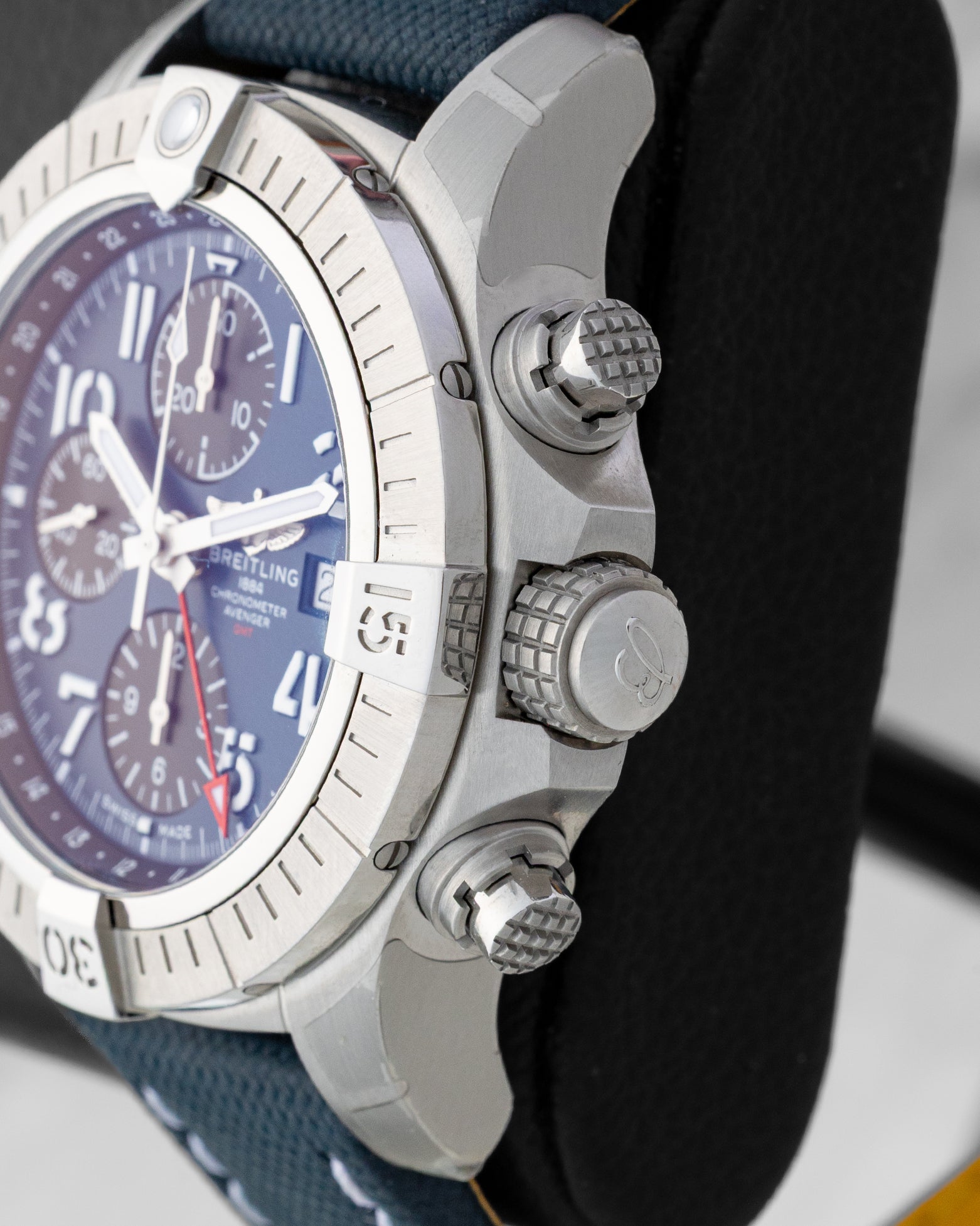 Side profile detail showing the 45mm stainless steel case, knurled screw-down crown, and chronograph pushers on a Breitling Avenger GMT A24315101C1X1