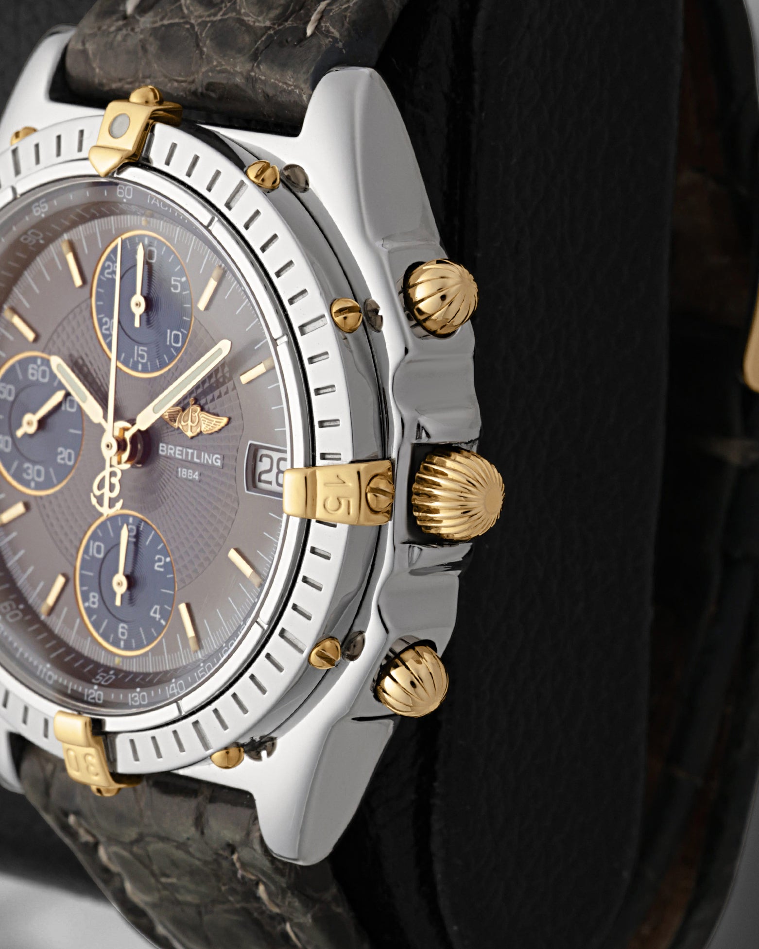 Close-up right-side profile of the two-tone watch head highlighting the classic 18k gold fluted onion-shaped winding crown paired with gold mushroom-style chronograph pushers