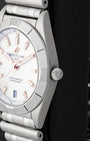 Close-up right profile view of the slim watch head focusing on the classic satin-brushed fixed bezel with engraved rider tabs and the fluted push-pull winding crown