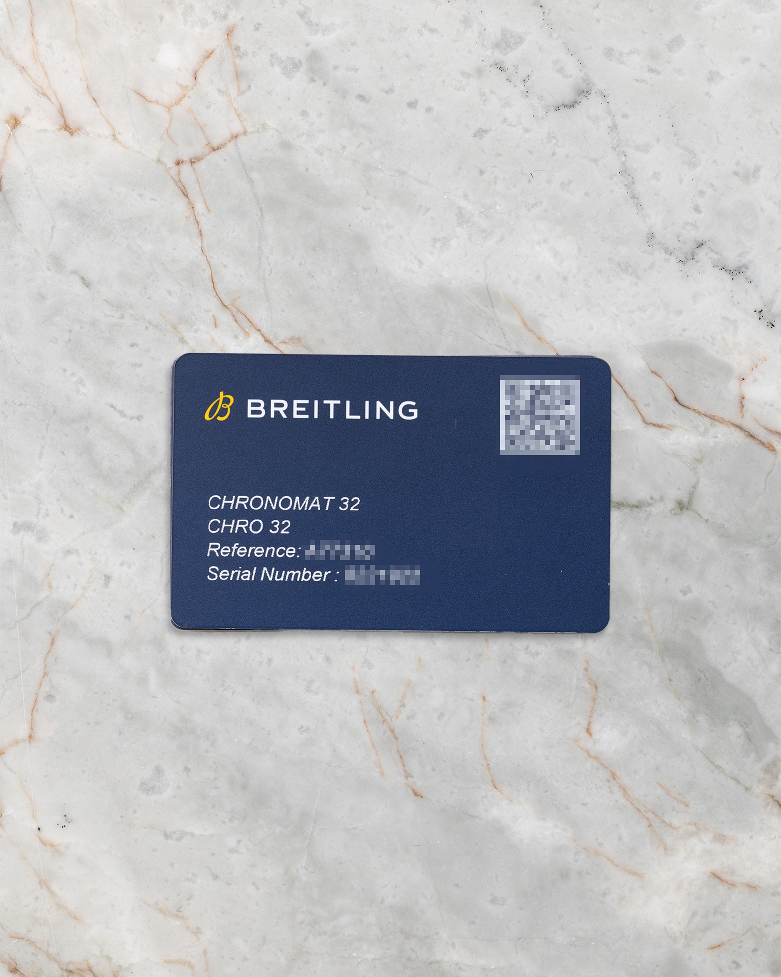 A top-down flat lay view of the official navy blue Breitling electronic warranty smart card showing the printed reference A77310 and a scannable registration QR code