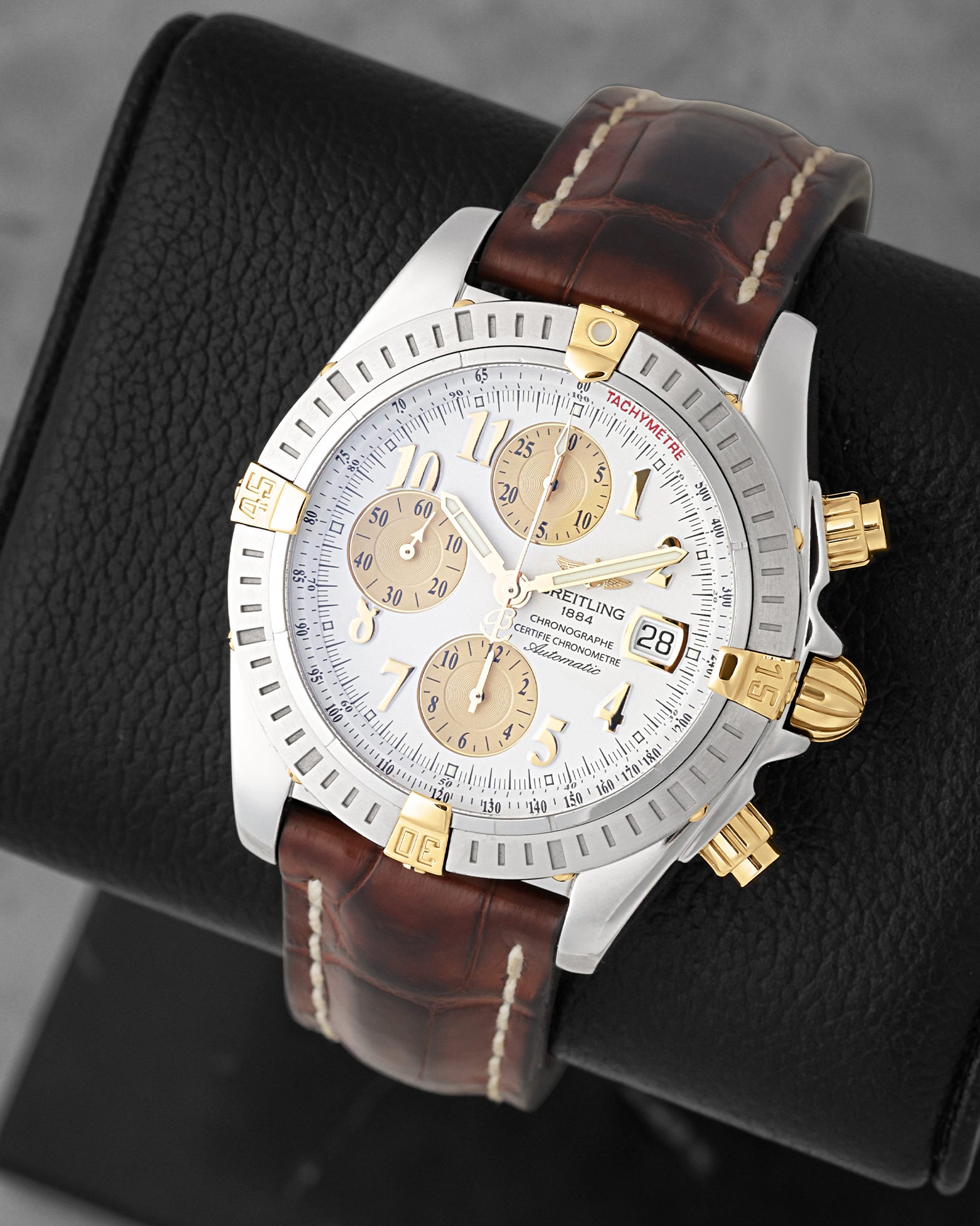 view of Breitling Chronomat Evolution B13356 featuring 18k yellow gold rider tabs, gold subdials, and brown leather strap