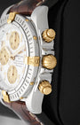 close up of 18k yellow gold screw-down onion crown and chronograph pushers on Breitling Chronomat Evolution B13356