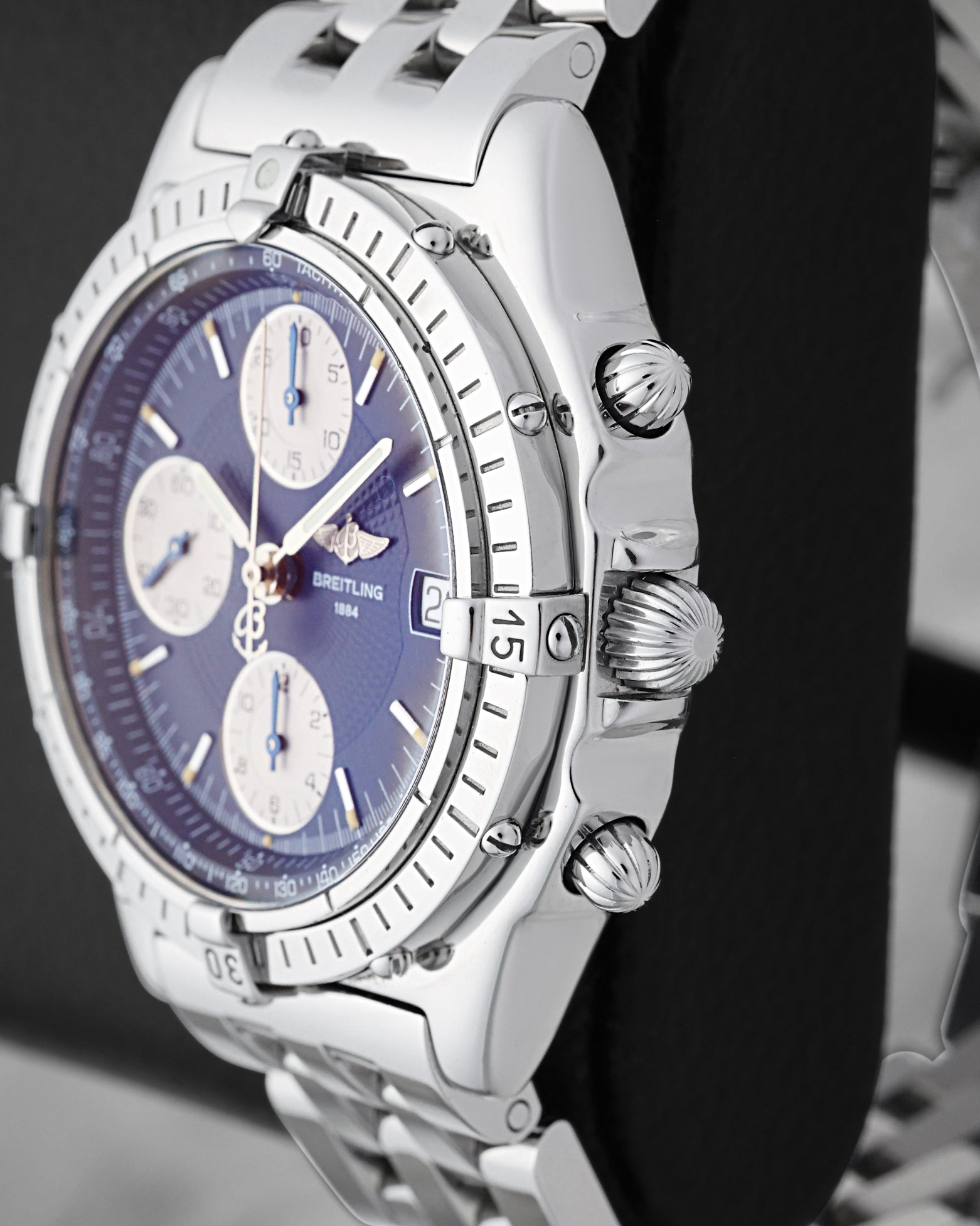 Right side profile view highlighting the signature onion crown, chronograph pushers, and unidirectional rotating bezel with rider tabs on a Breitling Chronomat A13050