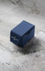 A clsoed blue Breitling sustainable fabric watch presentation travel box sitting on a textured grey marble background