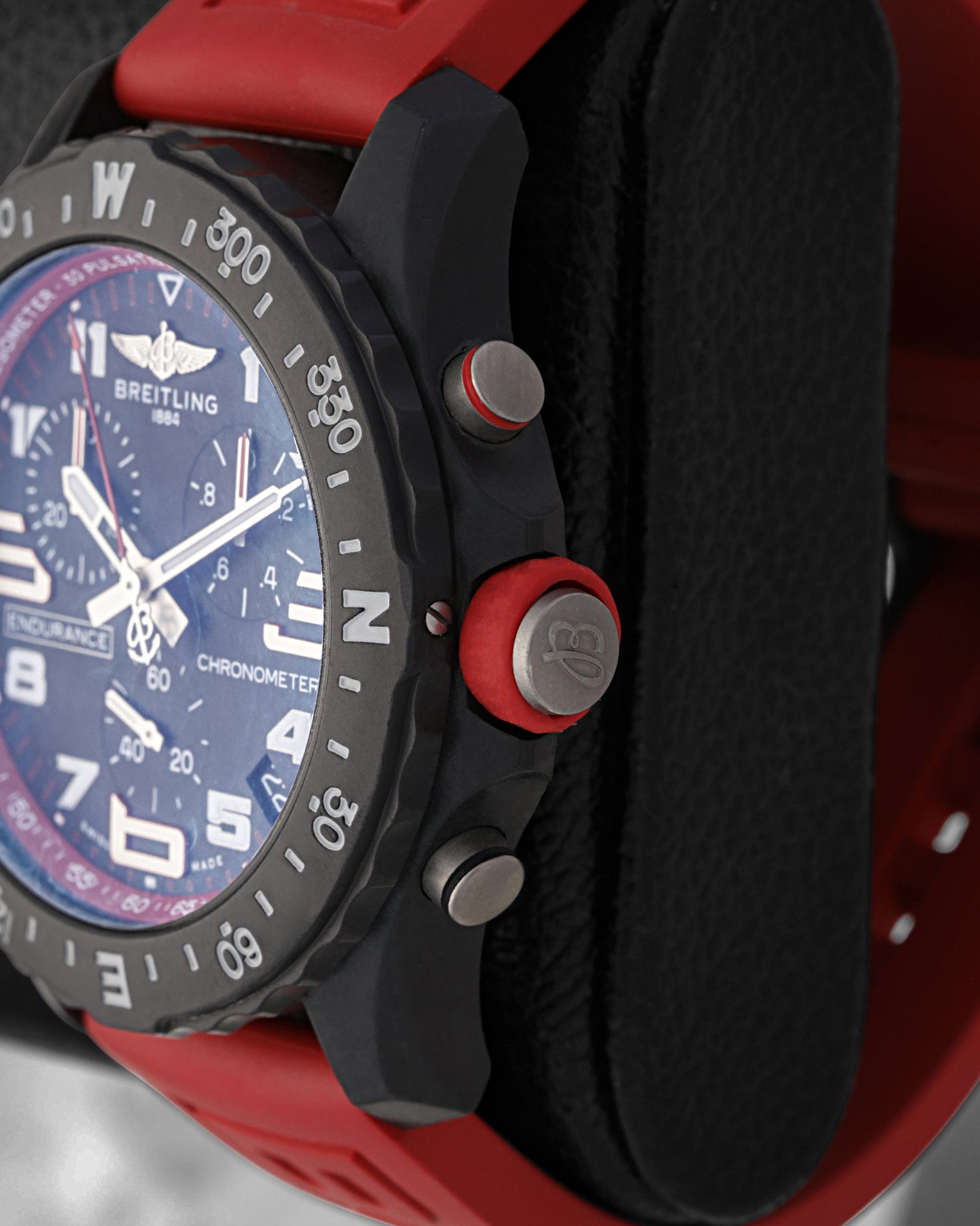 Close-up of the red rubber crown and chronograph pushers on a Breitling Endurance Pro 44