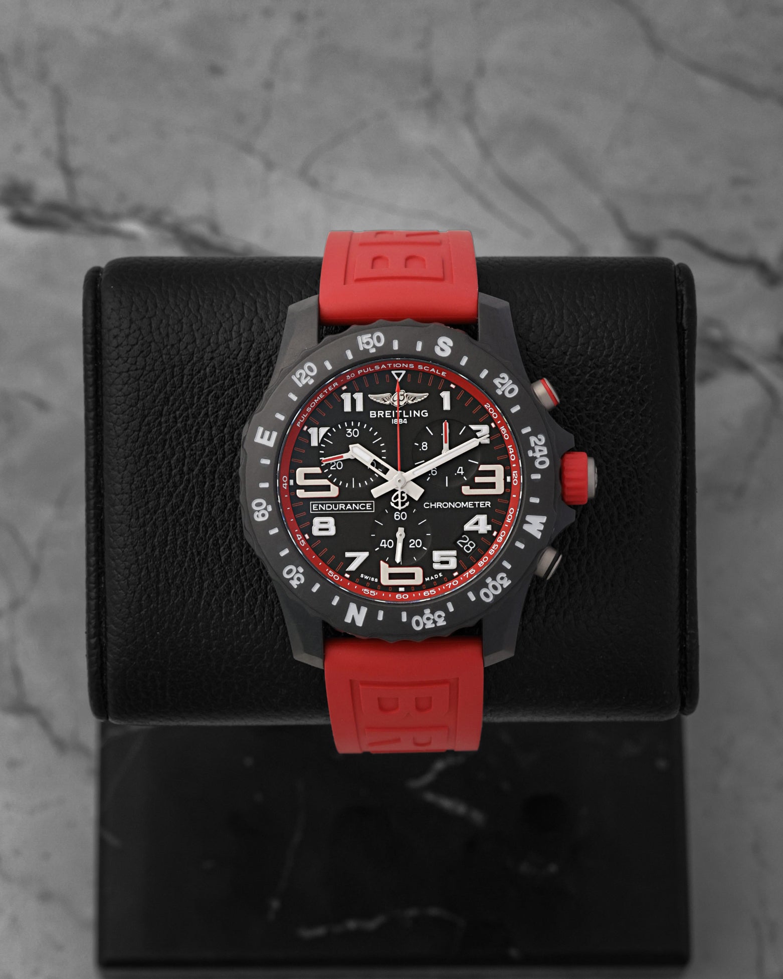 Front portrait of a pre-owned Breitling Endurance Pro 44 Ref X82310D91B1S1 featuring a black Breitlight case and red rubber strap, available at Noahs Fine Watches and Jewelry Dallas