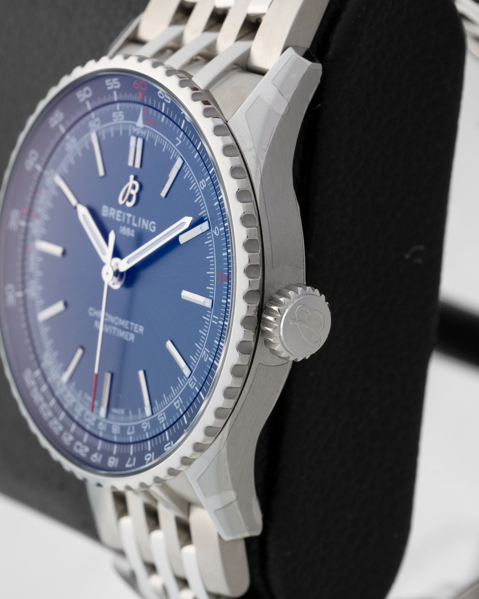 Side profile detail showing the 41mm stainless steel case, beaded slide rule bezel edge, and signed winding crown on a Breitling Navitimer A17329