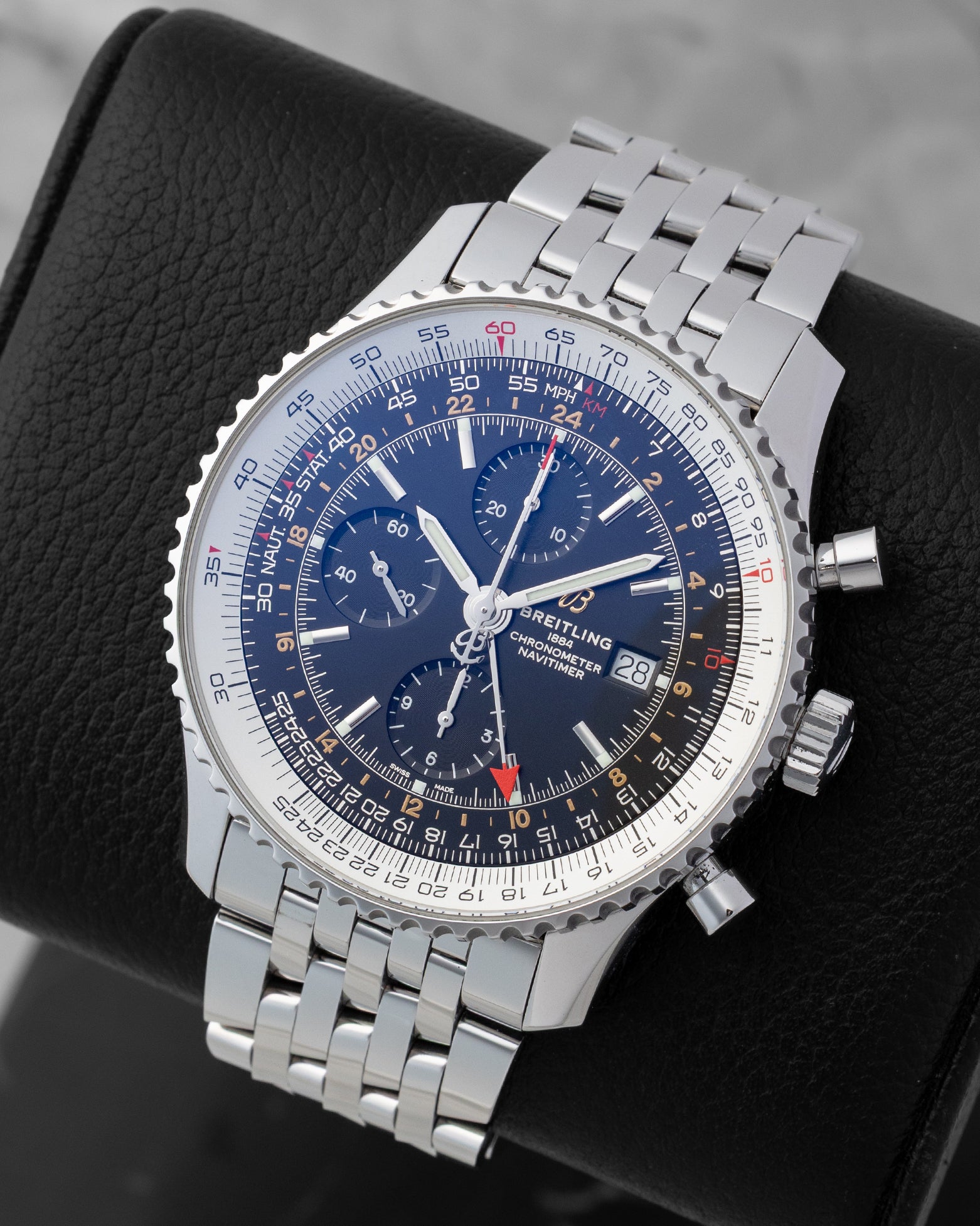 Angled front view of a preowned Breitling Navitimer World GMT A24322 featuring a black chronograph dial, red GMT hand, and bidirectional slide rule bezel