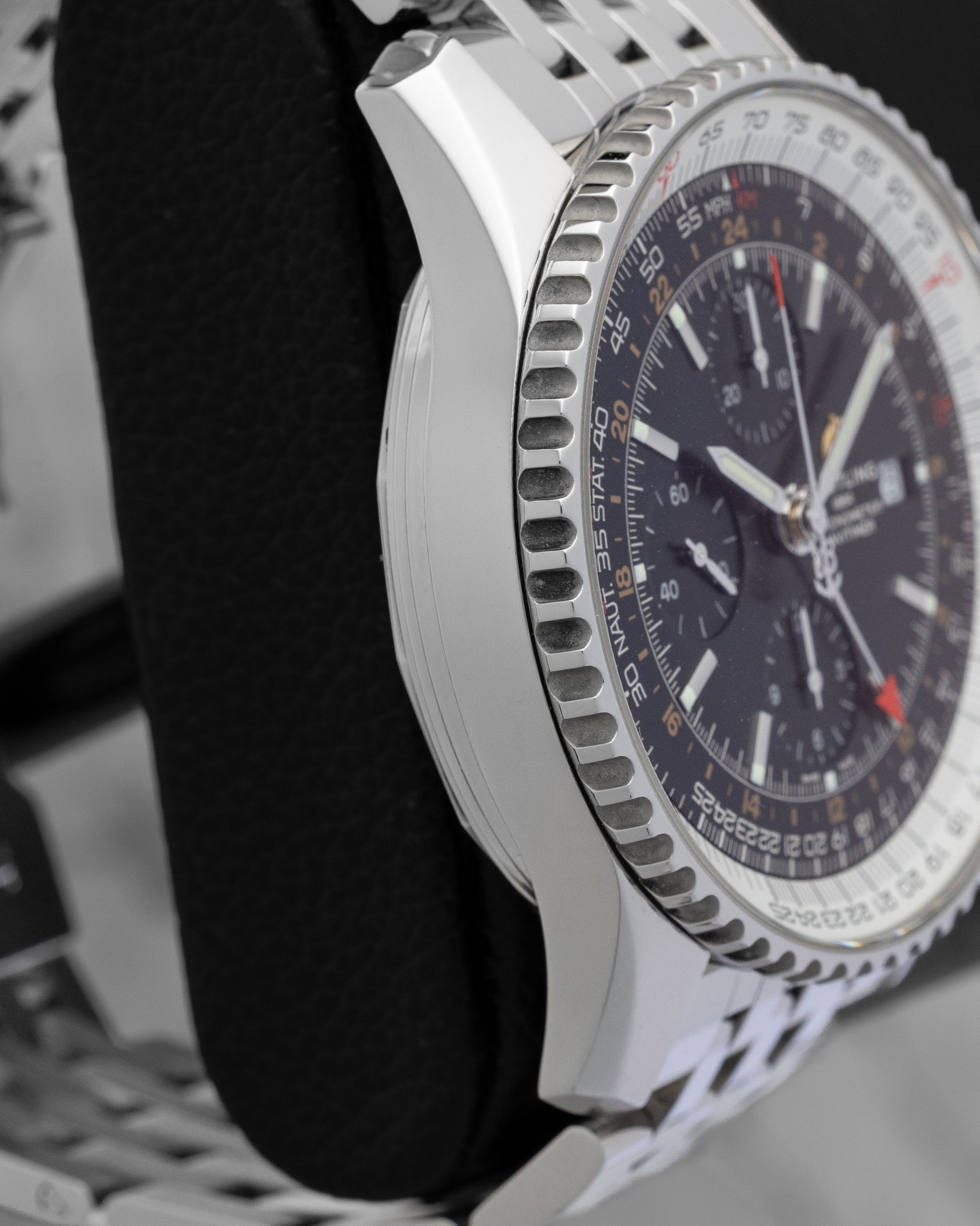 Left side profile view of the polished stainless steel case and slide rule bezel edge on a Breitling Navitimer World GMT reference A24322