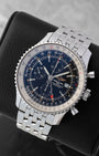 Angled front view of a preowned Breitling Navitimer World A2432212 featuring a black dial, red-tipped GMT hand, sub-dials, and bidirectional slide rule bezel
