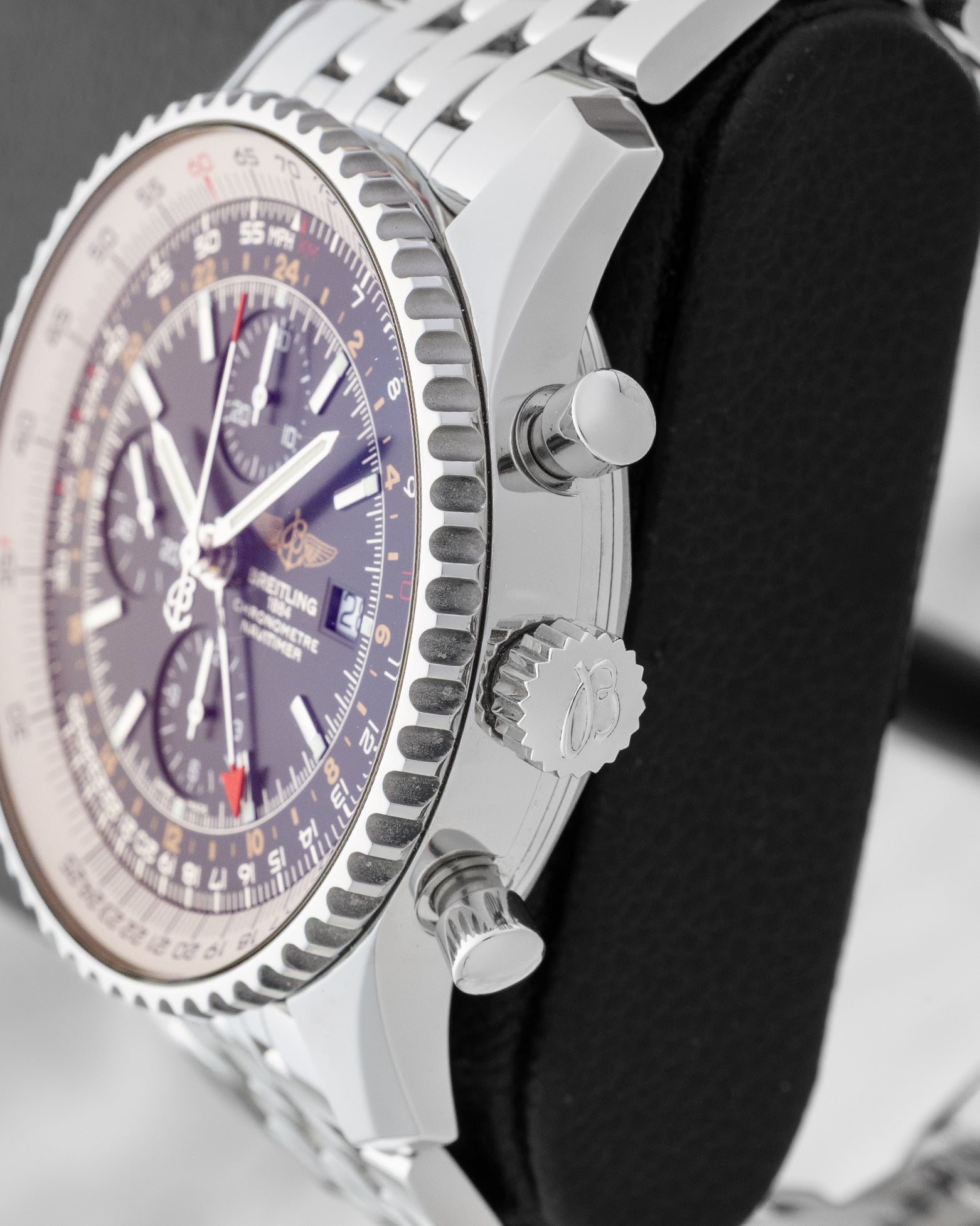Side profile showing the 46mm stainless steel case, signed winding crown, and chronograph pushers on a Breitling Navitimer World A2432212