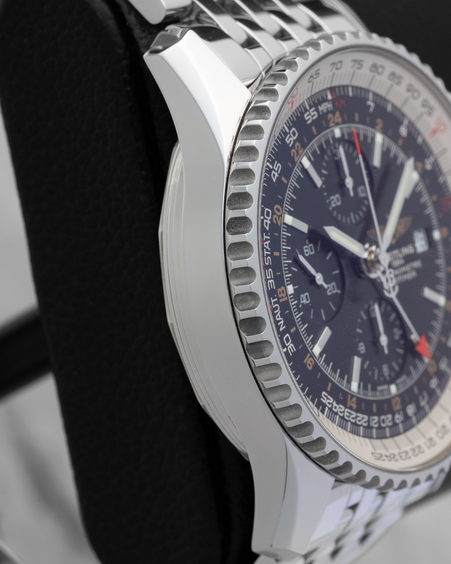 Left side profile view of the polished stainless steel case and slide rule bezel edge on a Breitling Navitimer World GMT reference A2432212