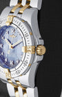 Two-tone case profile view showcasing the 18k yellow gold screw-lock winding crown and fluted bezel edge on a 30mm ladies Breitling Starliner