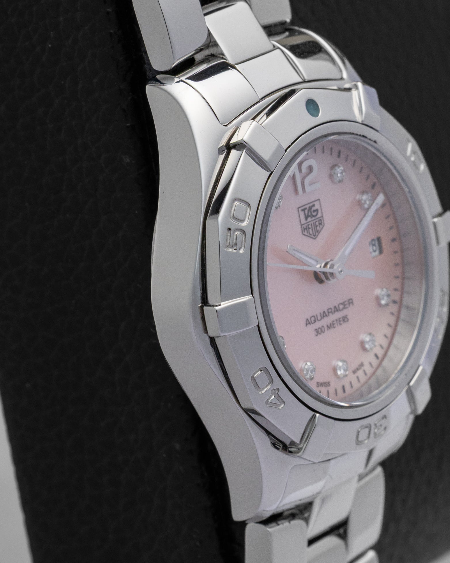 left side profile of the 27mm stainless steel case on a ladies TAG Heuer Aquaracer resting on a leather display cushion