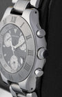 Macro case profile view showing the iconic crown guard profile with integrated white cabochon style detailing and polished steel chronograph push-buttons