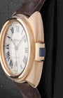 Close-up side profile of the Clé de Cartier case showing the unique rectangular key-shaped crown inlaid with a blue spinel