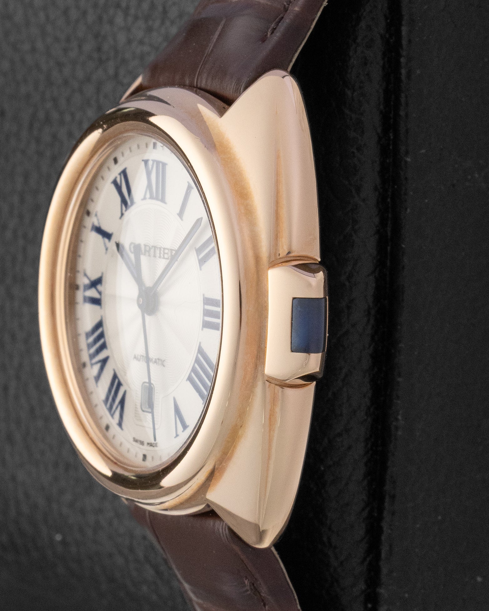 Close-up side profile of the Clé de Cartier case showing the unique rectangular key-shaped crown inlaid with a blue spinel
