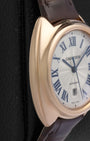 Macro close-up of a Clé de Cartier watch face with a sunray guilloche texture and blued-steel sword hands