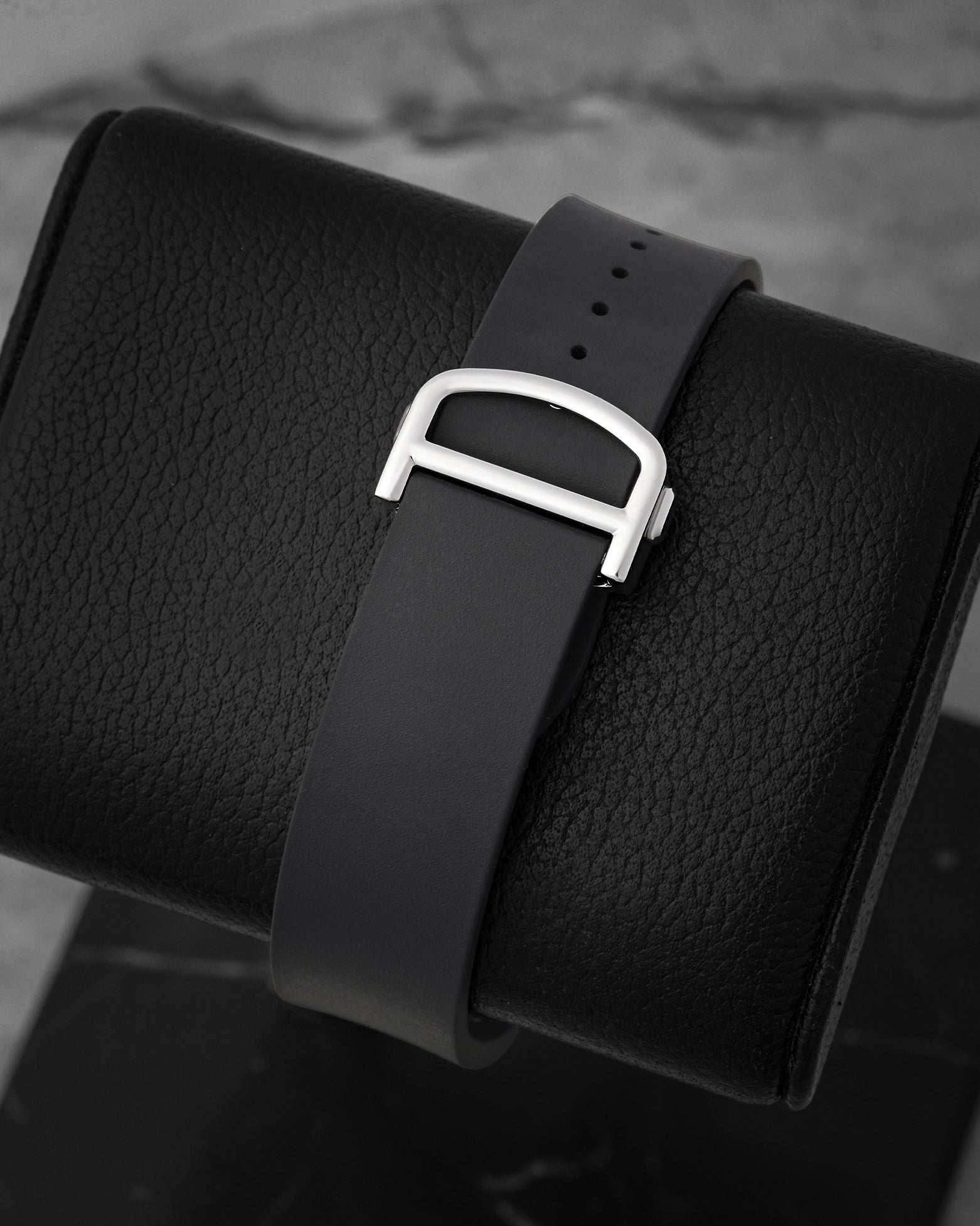 Rear perspective of the black rubber strap secured by a steel folding deployant buckle, highlighting Cartier's QuickSwitch interchangeable system