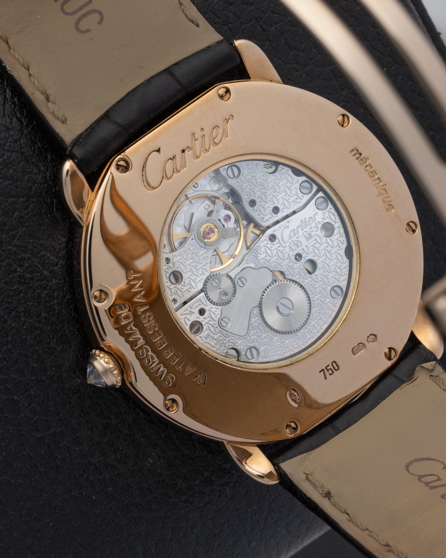 The clear sapphire caseback of a Cartier watch showing the manual-winding calibre 430 MC mechanical movement inside