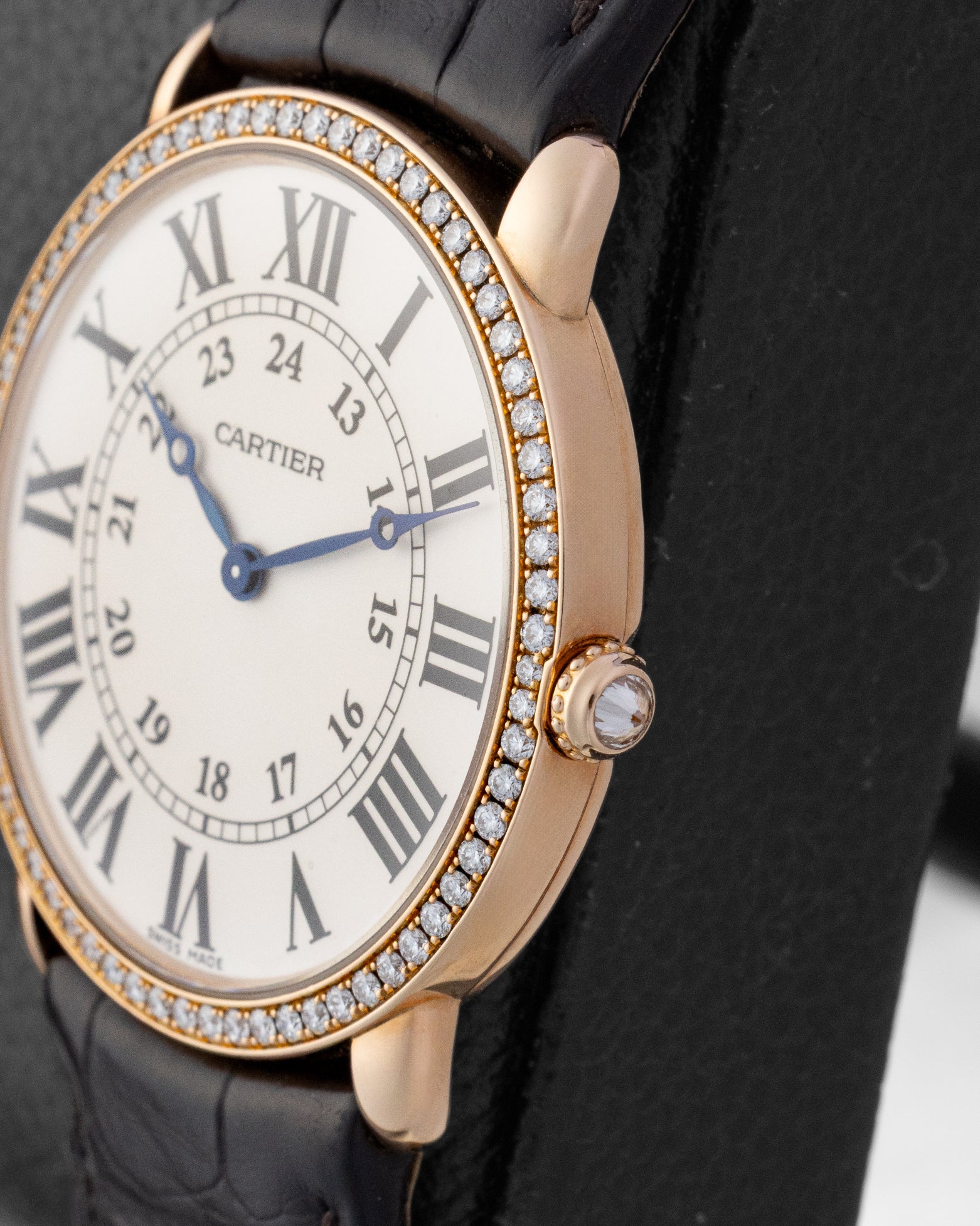 Close-up side profile of the rose gold Cartier case with circular-grained crown set with an inverted diamond