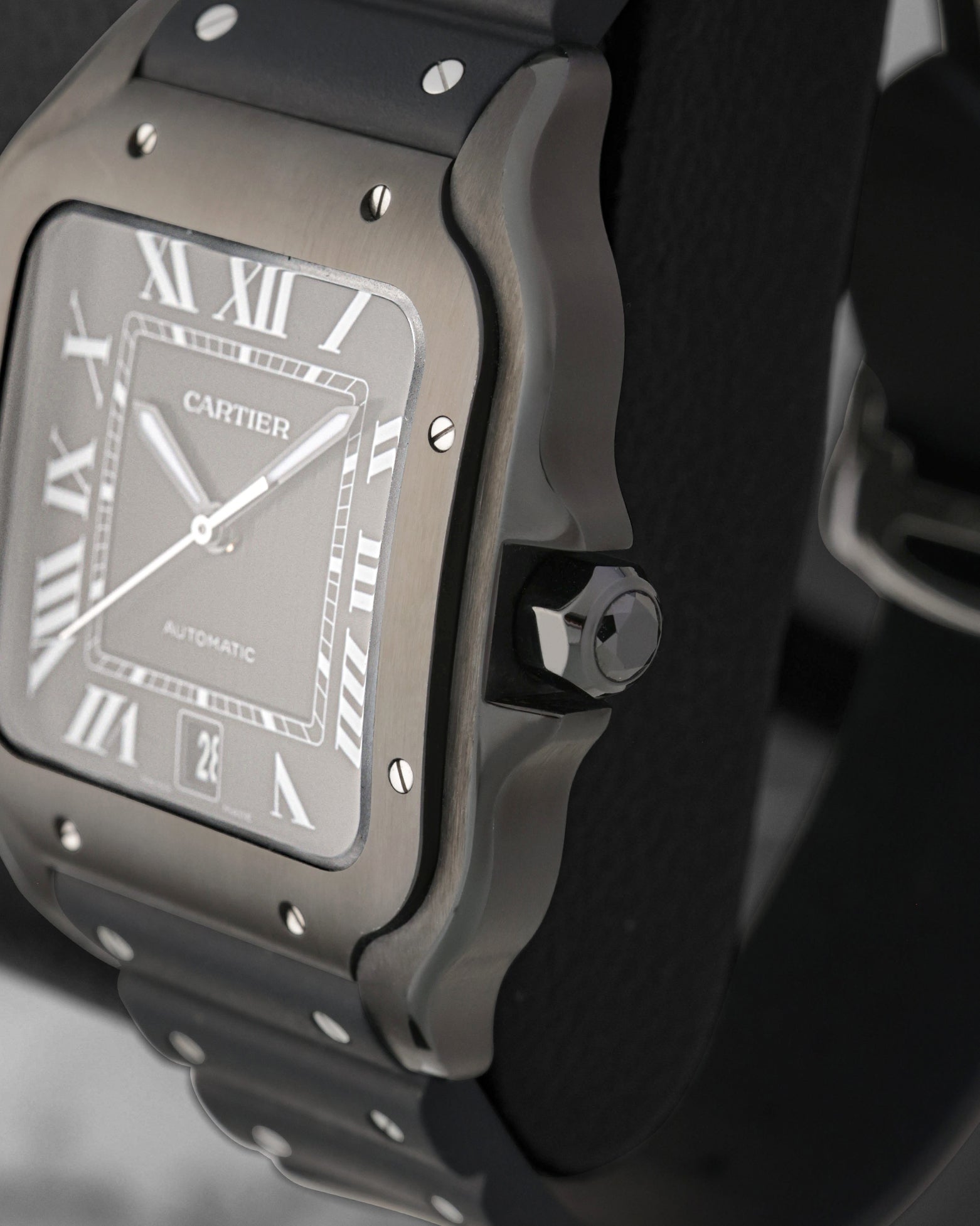 Side profile focus on the satin-brushed steel case architecture and the heptagonal winding crown set with a faceted black synthetic spinel