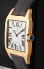 Side profile view displaying the beaded 18k rose gold crown set with a blue sapphire cabochon on Cartier Santos-Dumont W2006951