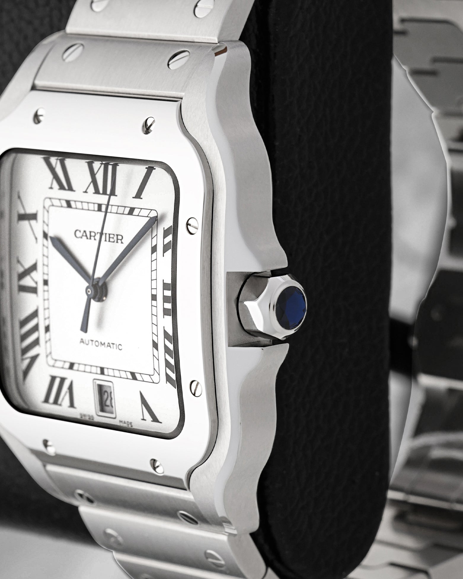 Profile view showing the 7-sided crown set with a blue synthetic spinel cabochon on a Cartier Santos WSSA0018